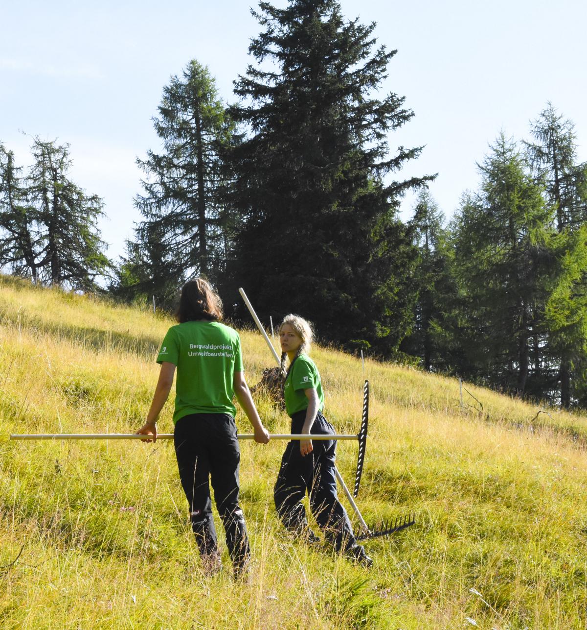 Zwei Teilnehmerinnen mit Rechen auf dem Weg zur Weidefl&auml;che, Foto: &Ouml;AV