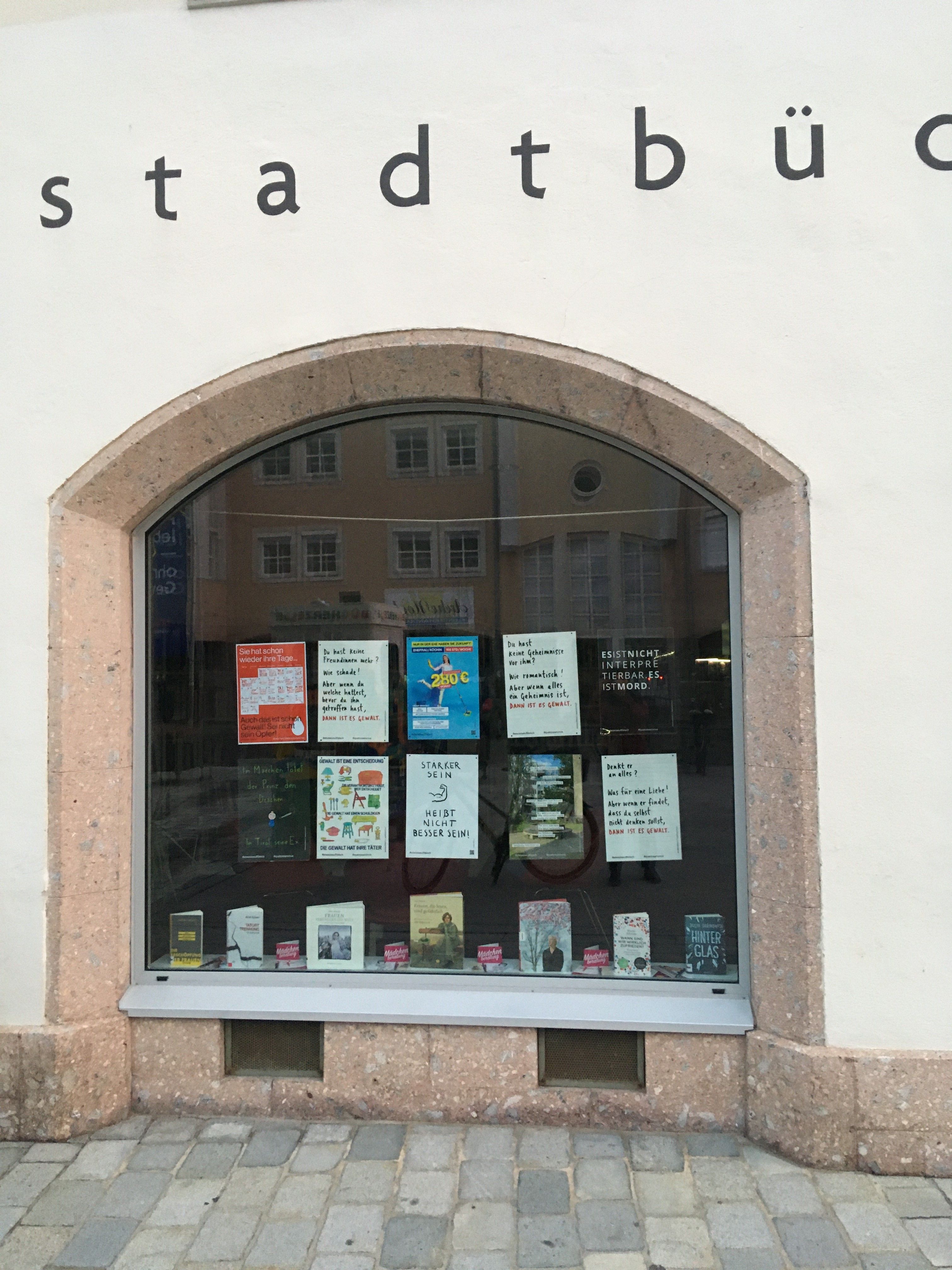 Plakate der Kunstaktion im Schaufenster der Stadtb&uuml;cherei Lienz. Foto: Frauenzentrum Osttirol