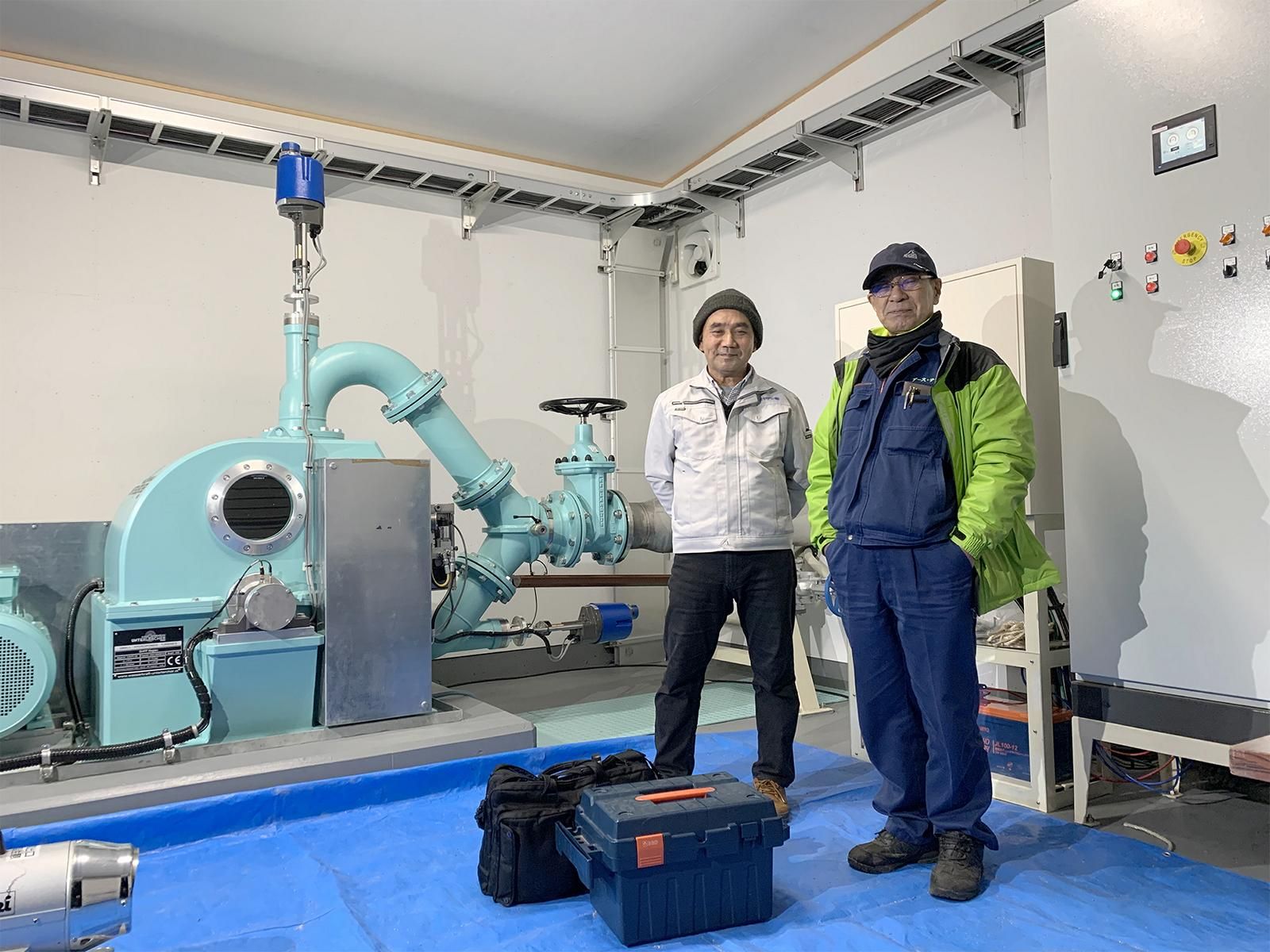 Ein fertig installiertes Tiroler Kleinkraftwerk mit den stolzen Betreibern in Japan