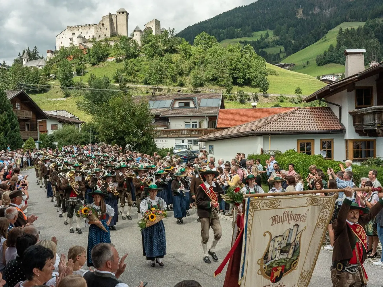 Die Musikkapelle Heinfels mit der Burg Heinfels im Hintergrund. 