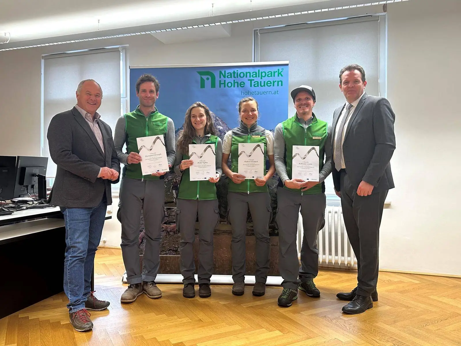 Vier neue hauptberufliche Ranger:innen in Osttirol: Christoph Dietmaier, Sophie Thaler, Elisabeth Fladerer und Armin Kollreider mit Nationalparkdirektor Hermann Stotter und Landesrat René Zumtobel bei der Urkundenübergabe am 9.12.2024 in Innsbruck, Foto: Knabl, Land Tirol