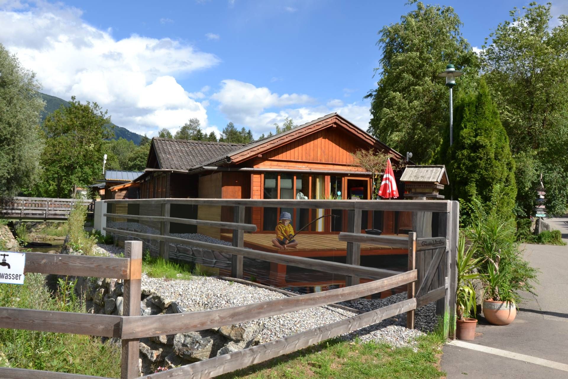 Was ist echt - was ist gemalt? Eine unansehnliche Hochwasser-Schutzmauer beim Sport-Erlebniscamp Pristavec in Obervellach verwandelte sich in ein beeindruckendes 3D-Kunstwerk. Auch hier gibt es am Boden einen &bdquo;Fotopoint&ldquo;, von dem aus die Grenzen zwischen Bild und Geb&auml;ude verschmelzen.